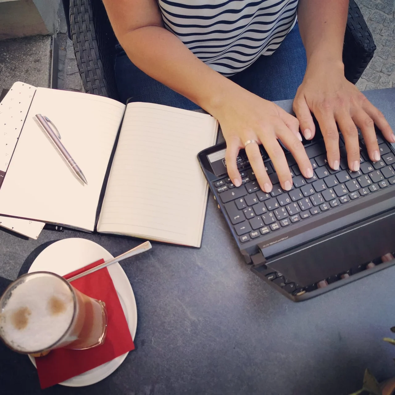 Laptop, Notizbuch und Kaffee für ein Onlinegespräch